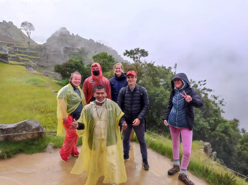 Turistas con poncho caminando por Machu Picchu en febrero