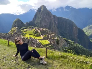 Turista disfrutando Machu Picchu con clima soleado en junio