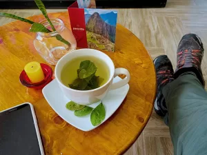 Turista bebiendo mate de coca en Cusco para prevenir mal de altura